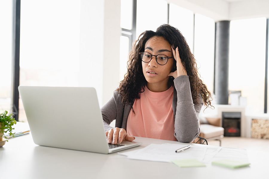 young african-american woman sitting in front of laptop concerned about failure